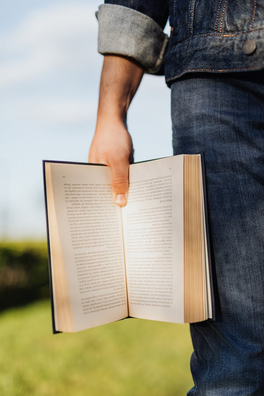 crop male student with open book lit up by sunlight